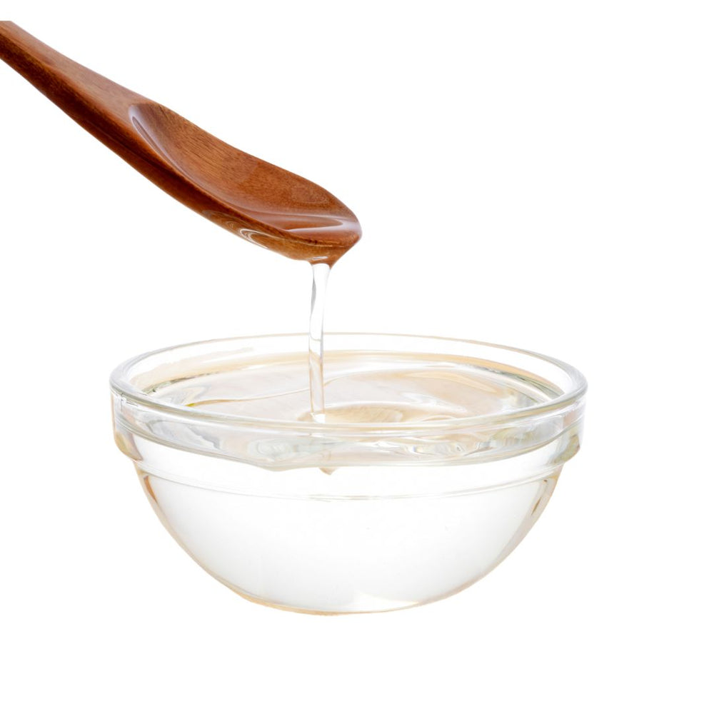 Wooden spoon dripping honey into a bowl highlighting SuperGreen Powders for immune support